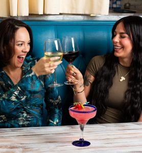 two female guests cheering with glasses of wine